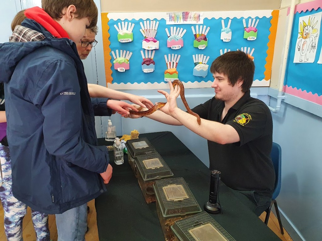 Ben, Daniel, and Elizabeth touching a corn snake.
