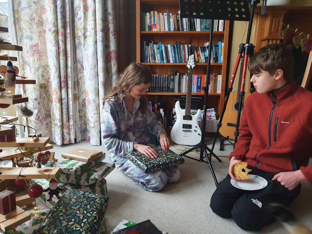 Elizabeth opening a present with Daniel watching.