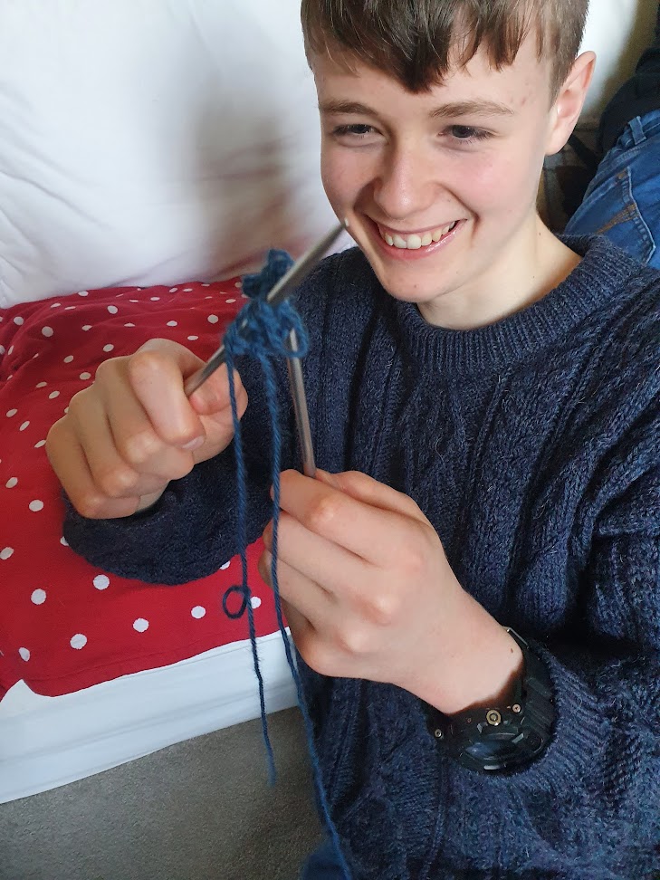 Daniel attacking his yarn with knitting needles