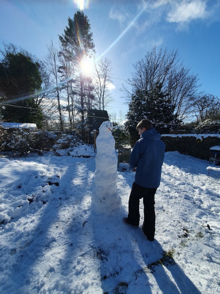 Daniel putting the finishing touches on his snowman