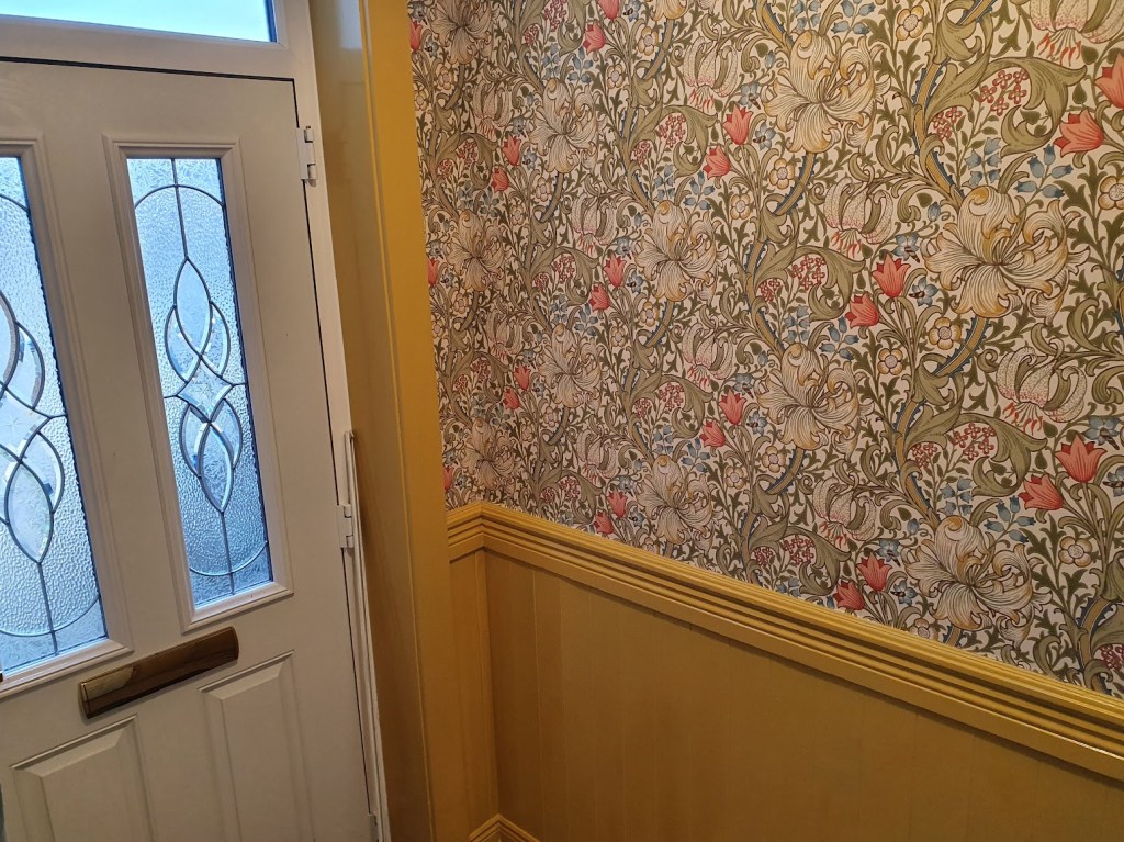 A view of the front door and one wall of wallpaper