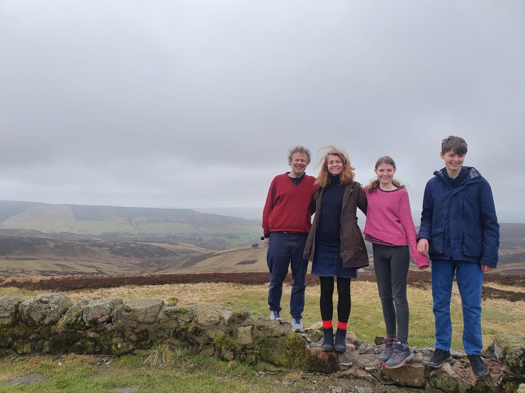 Photo of the four of us with a view to the glen behind us.