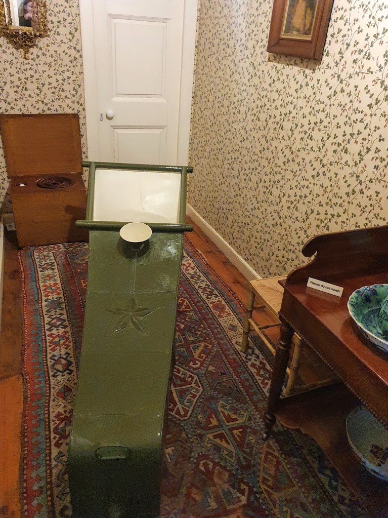 Bath at House of Dun. It's green and almost fully enclosed with a small opening at the top. It is rectangular in shape with hard edges and features a star on the top.