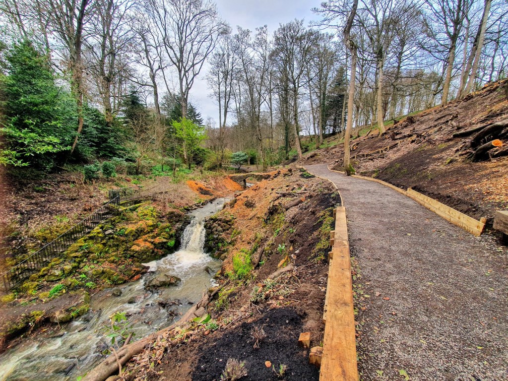 The woodland pathway with a stream on the left and a small waterfall.