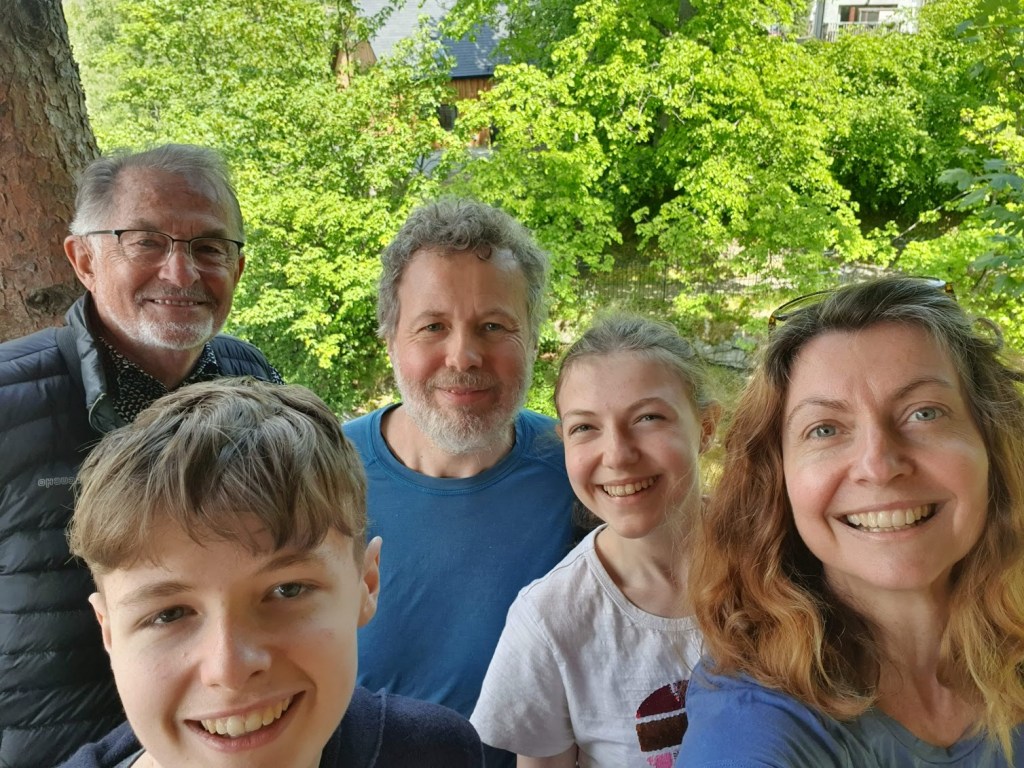 A selfie of all of us next to our table at the bothy with the river behind.