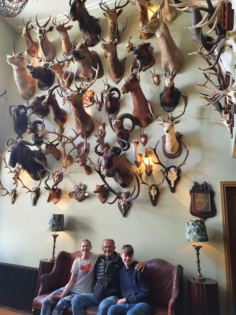 Dad, Daniel, and Elizabeth at the Fife Arms beneath all the animal heads.