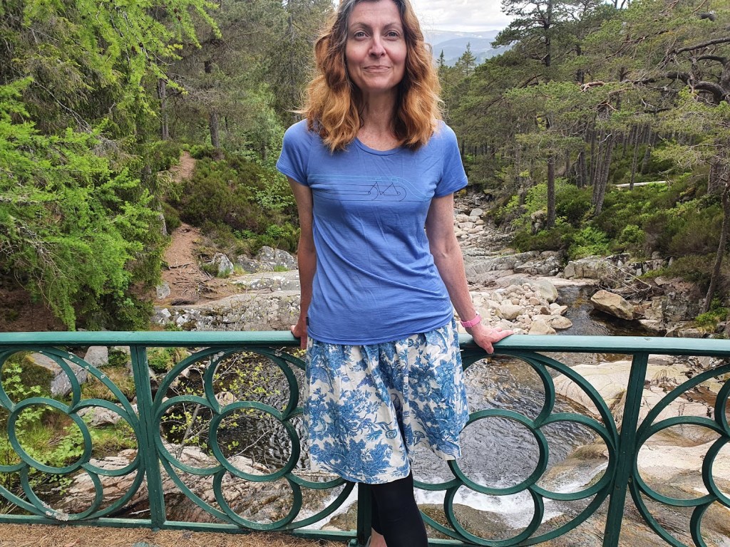 Me on the bridge with the river, forest, and hills behind me. 