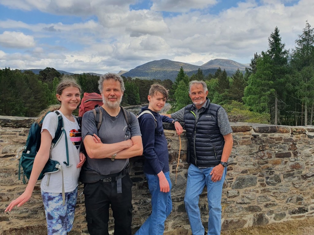 Elizabeth, Ben, Daniel, and Dad on the Invercauld bridge with hills in the background.