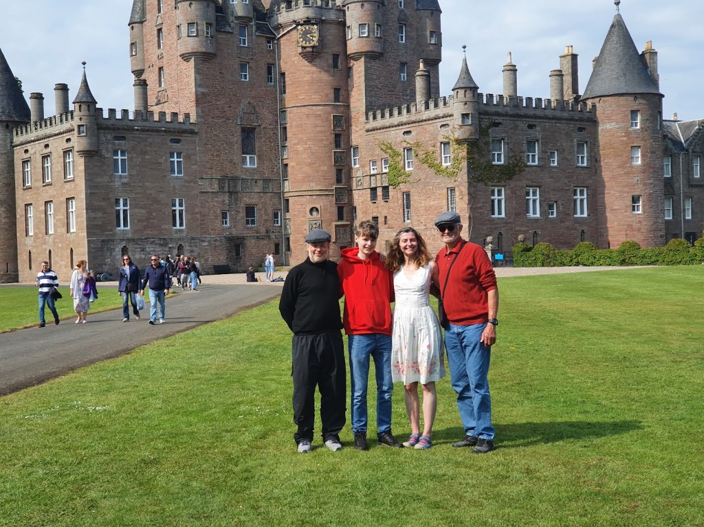 Ben, Daniel, Elizabeth, and Grandad standing in from of Glamis Castle