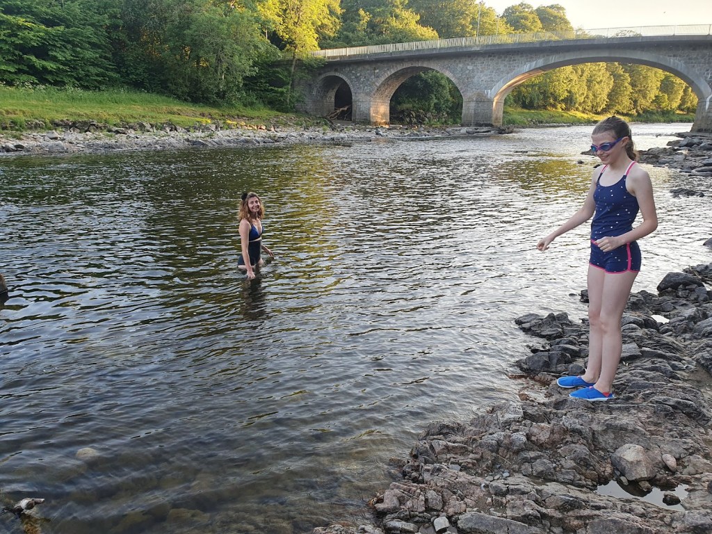 Rachel in the river and Elizabeth contemplating coming in.