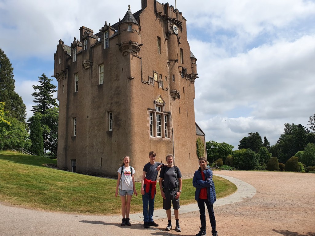 Elizabeth, Daniel, Ben, and Etienne standing in front of the castle