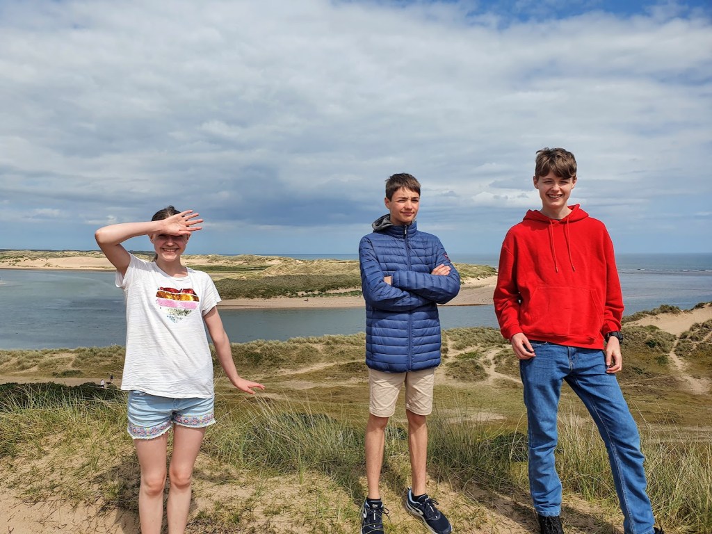 Elizabeth, Etienne, and Daniel on the hill with the estuary behind them.