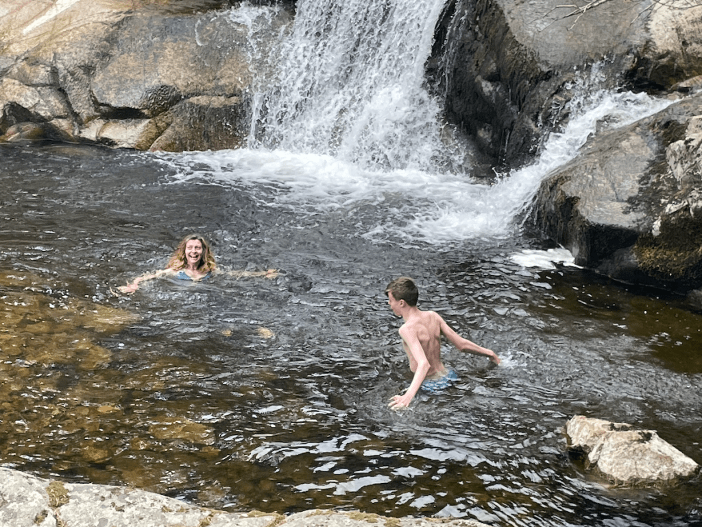 Rachel and Daniel swimming beneath the waterfall.