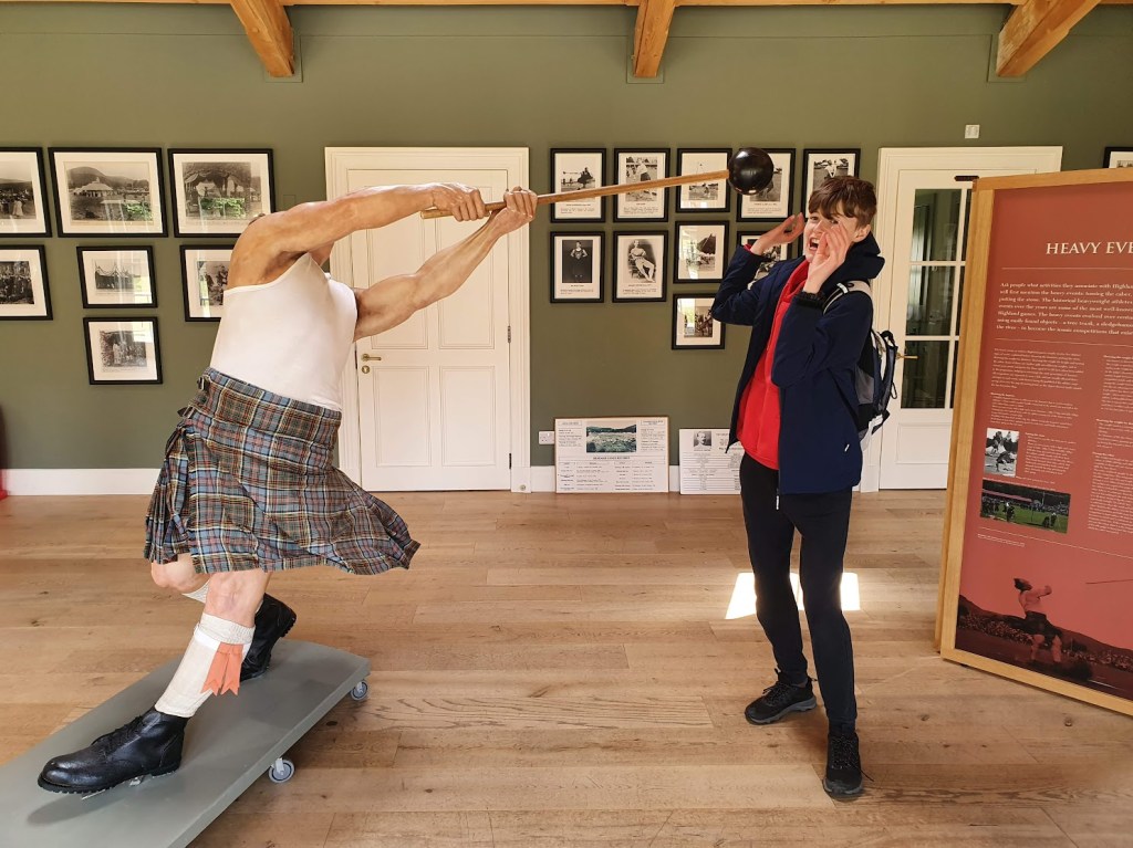 Daniel standing next to a statue of a man doing the hammer throw.