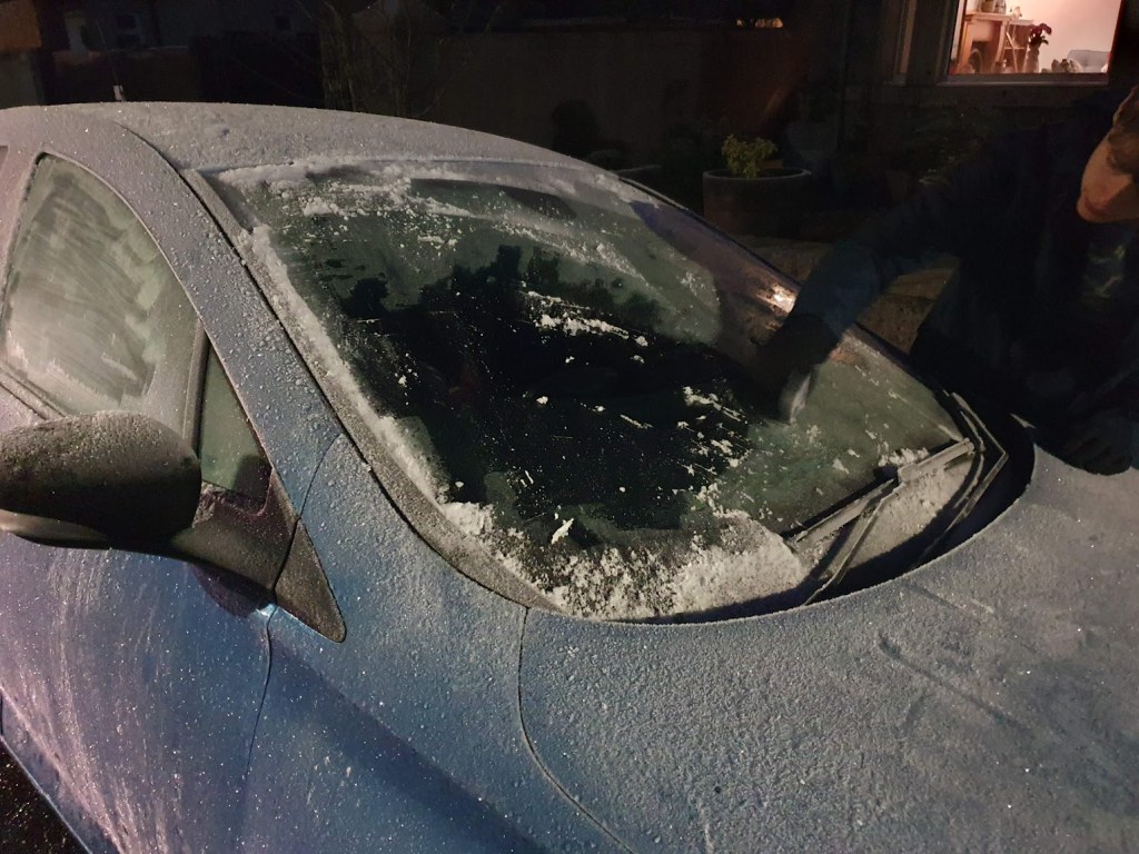 Daniel scraping the ice from the windscreen of our car.