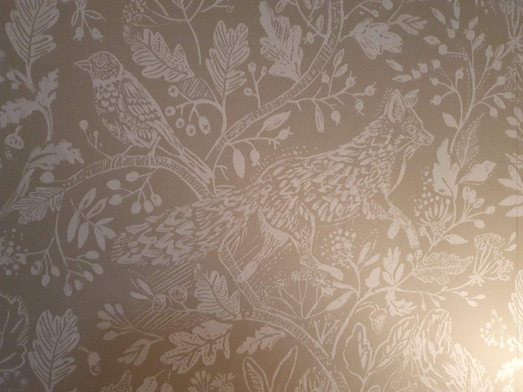 A close-up of the wallpaper whosing a fox and bird.