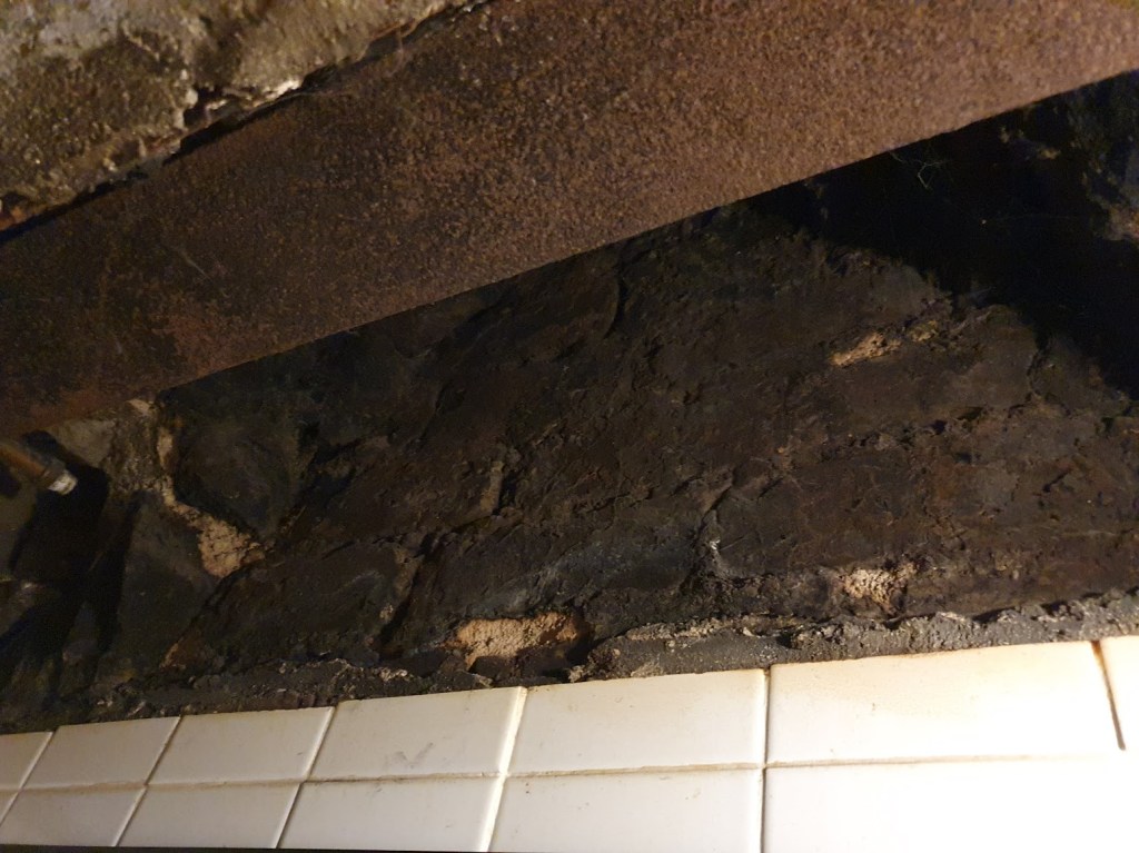 Chimney hole covered in soot and cobwebs.