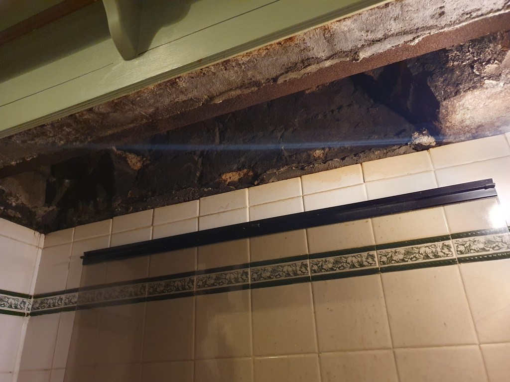 The chimney hole above the tiles behind the hob.