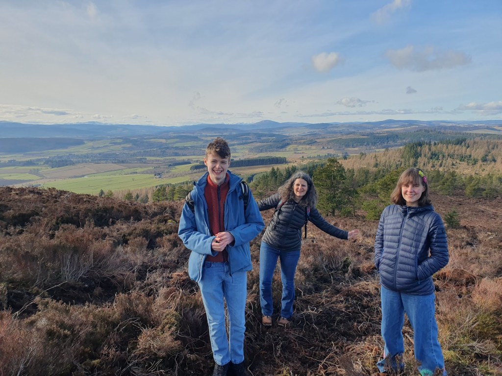 Daniel, Aileen, and Máiri with Lochnagar in the distance behind them.