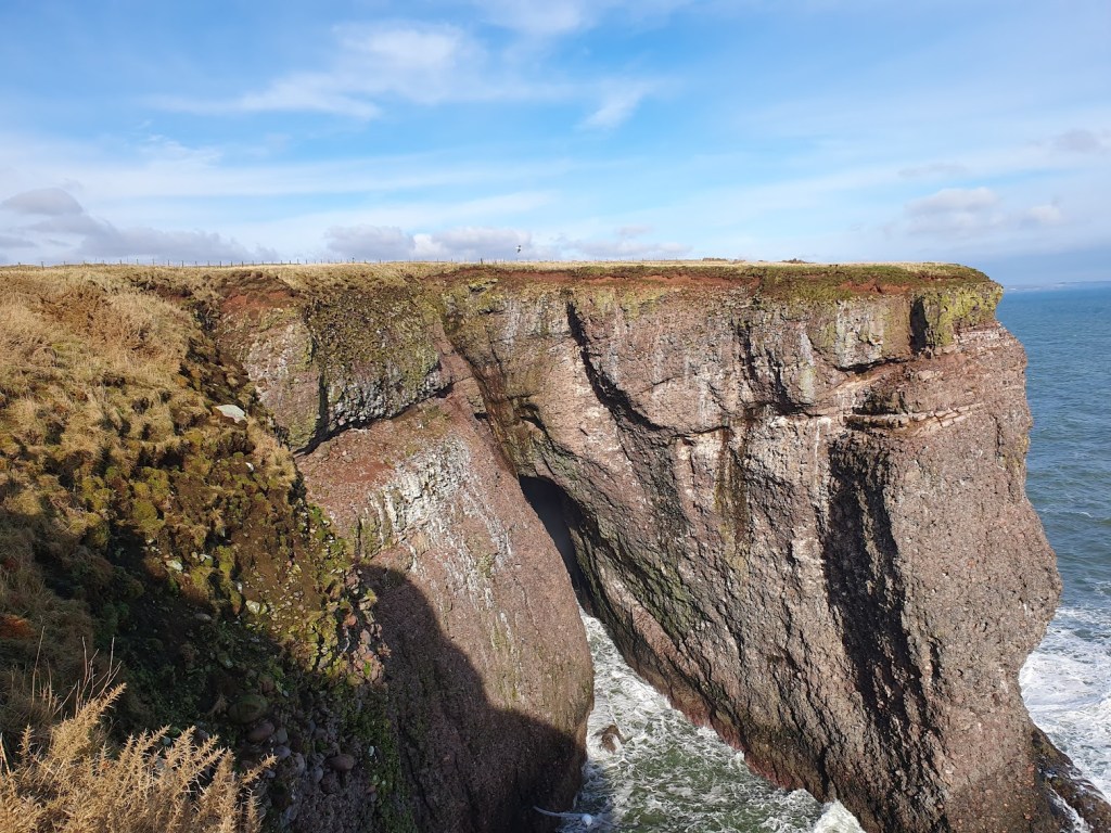 Another view of the cliffs with a cave below. 