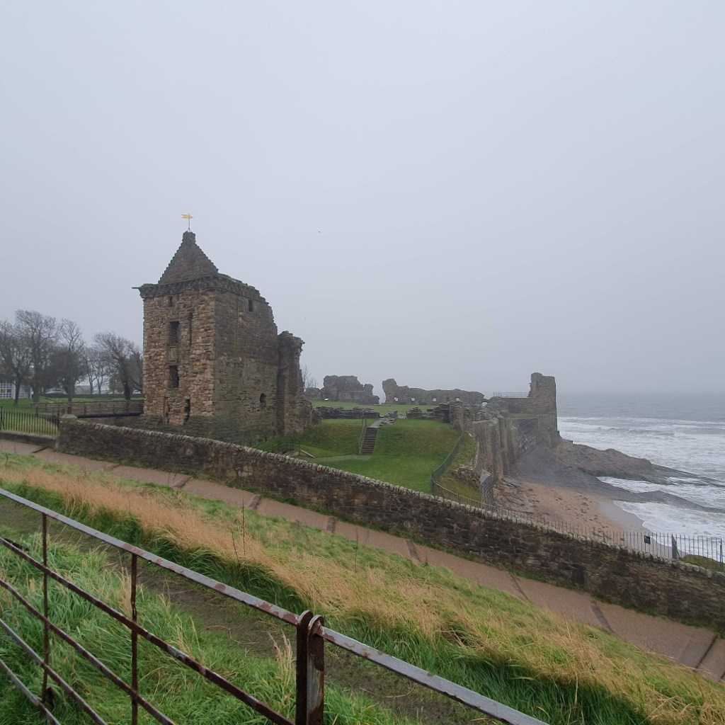 St Andrews Castle ruin beside the sea on a cold foggy day.