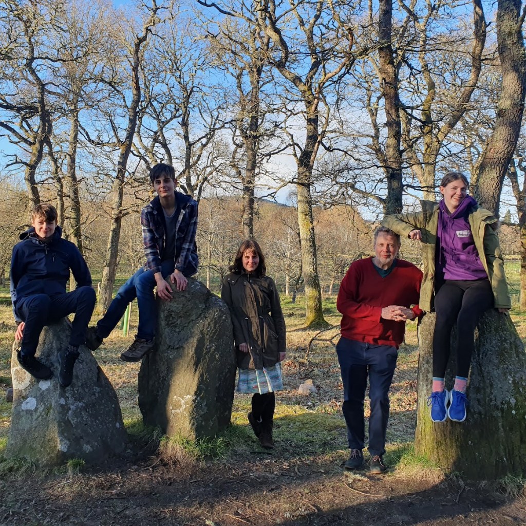 Five people all casually posing with the standing stones and looking cool. 