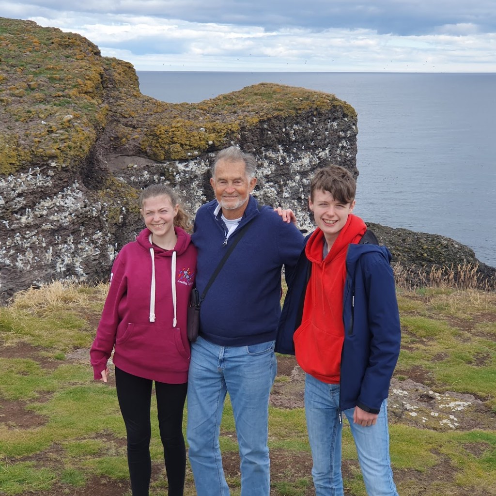 Elizabeth, Dad, and Daniel with the cliffs and the north sea behind them.