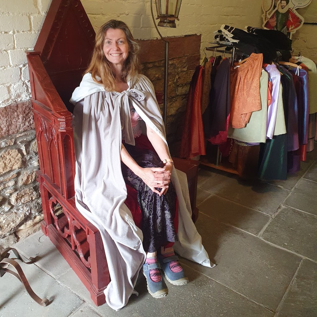 Rachel sitting in the regal chair wearing a cape.