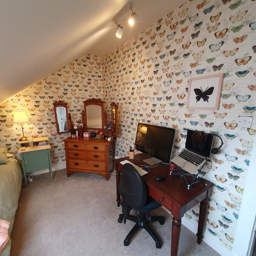 Another view of the wallpaper with a crochet butterfly on the wall