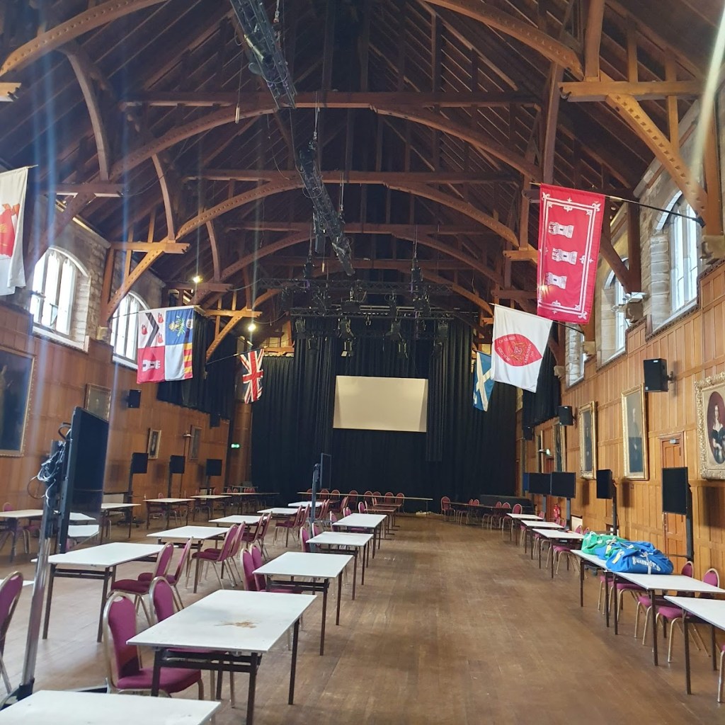 A large hall with timber panelling on the walls and a timber-framed ceiling.