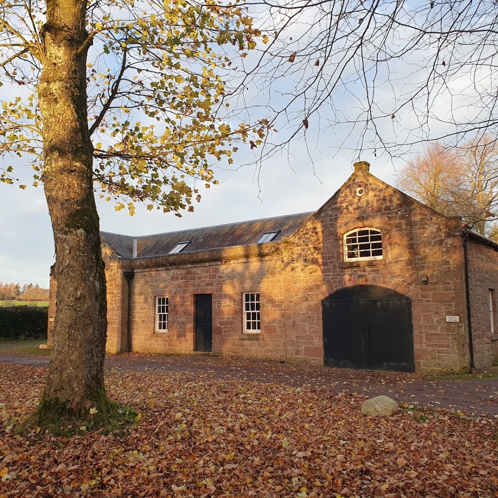 The stables - an attractive stone building with a large wooden entrance.