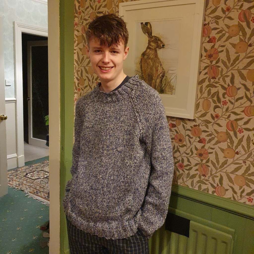 Daniel wearing his blue knitted jumper.