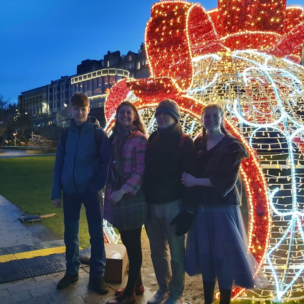 Daniel, Rachel, Ben and Elizabeth in front of a Christmas decoration .