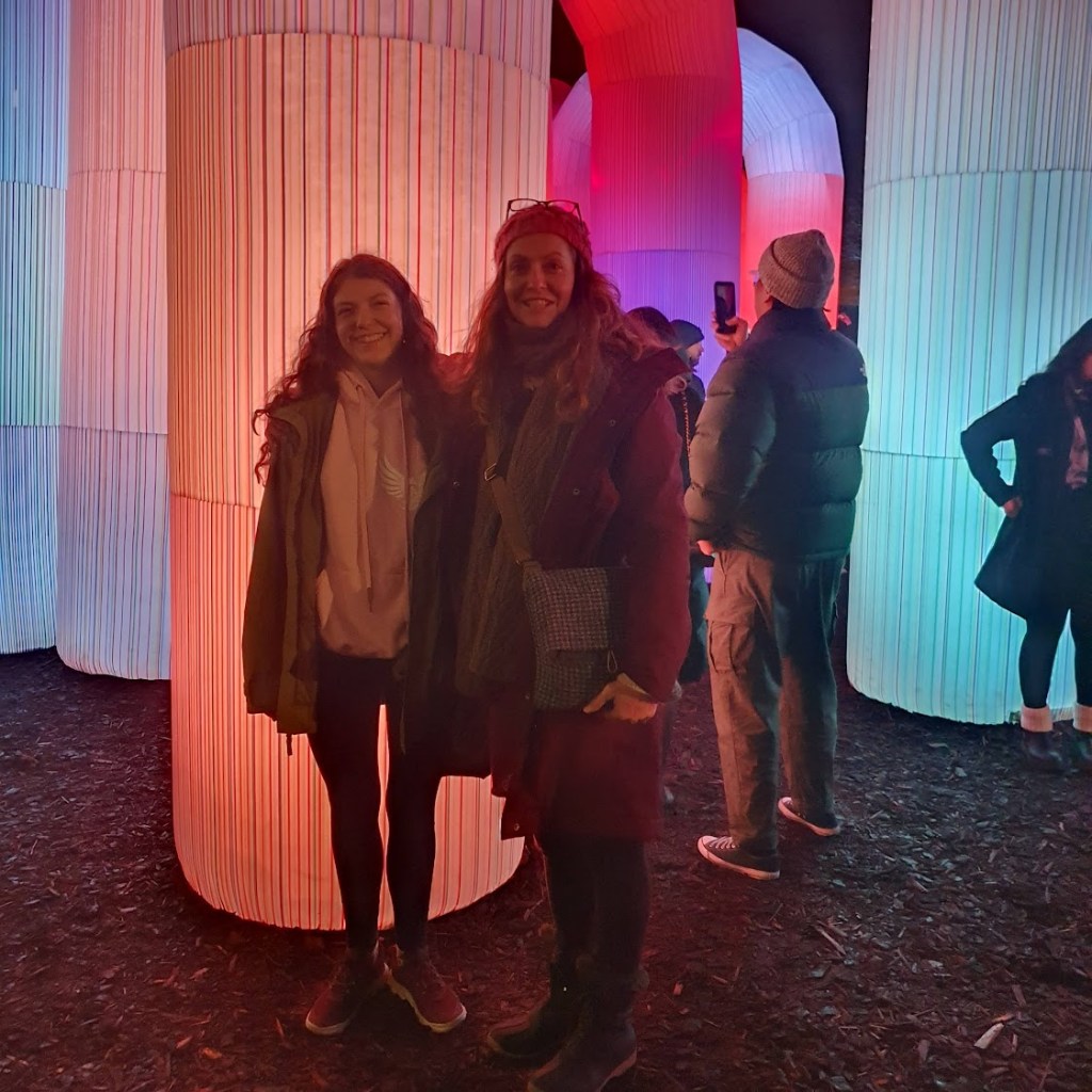 Rachel and Elizabeth smiling in front of one of the upside down Us.