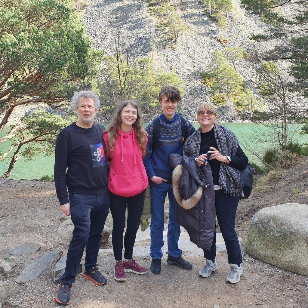 Ben, Elizabeth, Daniel and Mum smiling in front the loch.
