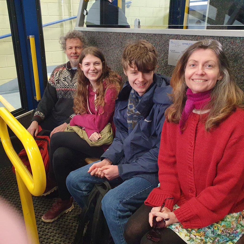 Ben, Elizabeth, Daniel and Rachel sitting inside a train carriage.