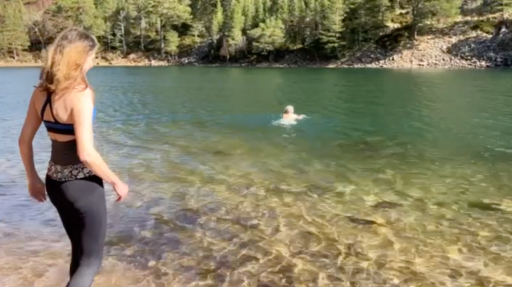 Daniel splashing in the loch, Rachel swimming, Ben swimming, and Elizabeth wading.