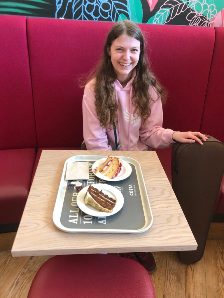 Elizabeth smiling with two slices of cake before her.