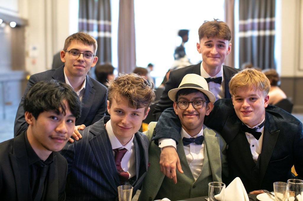 Daniel seated at his table with friends.