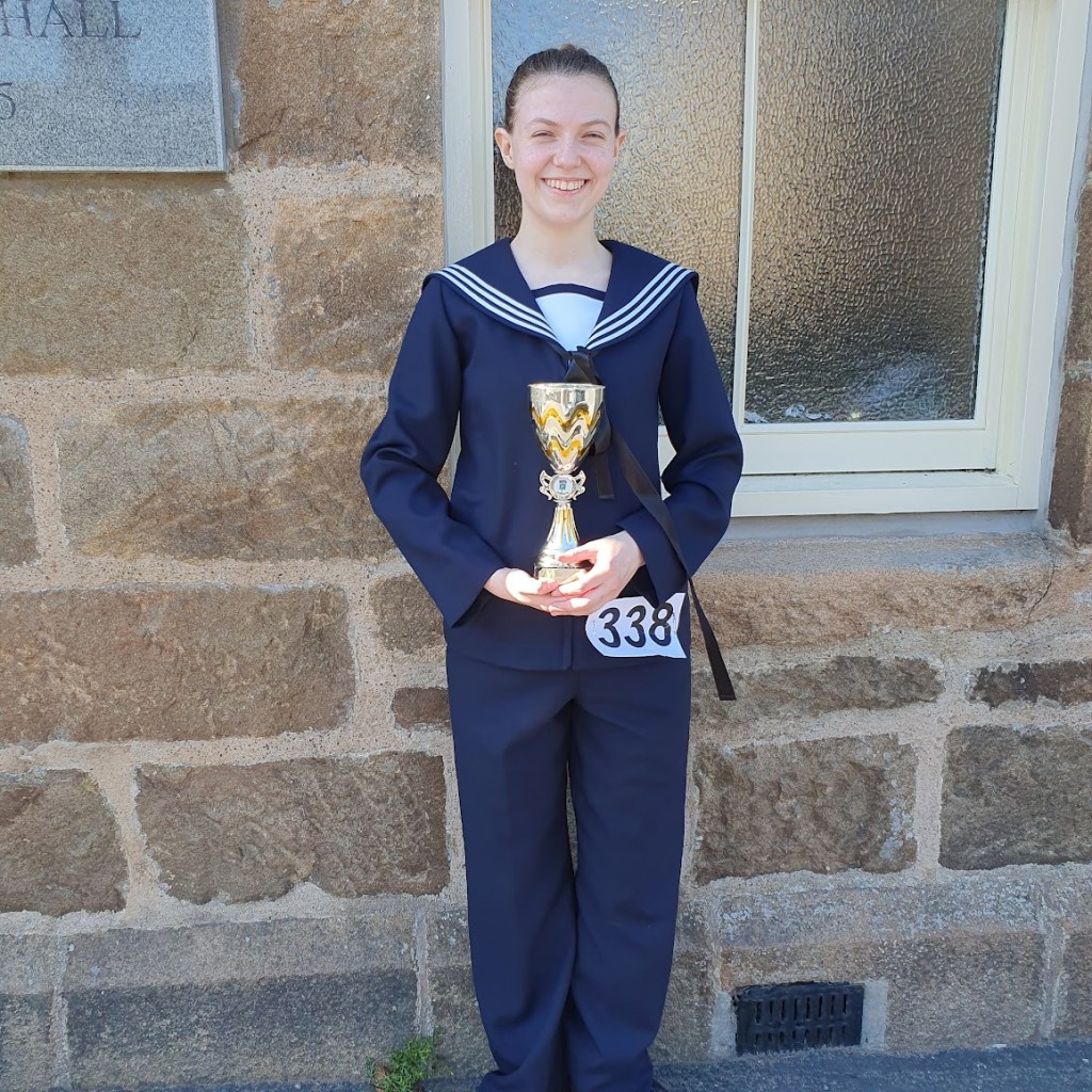 Elizabeth in the hornpipe outfit holding her trophy.