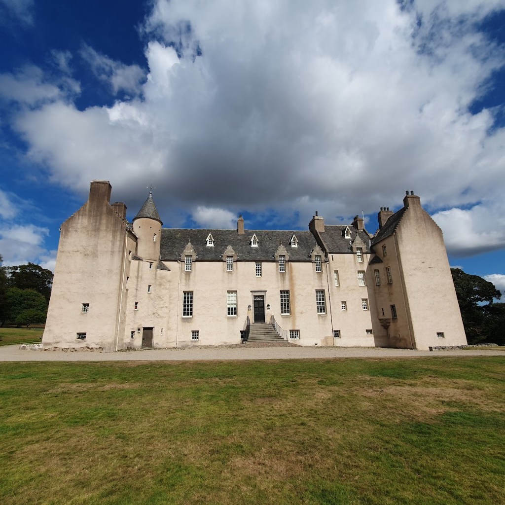 Drum Castle from the front with a blue sky backdrop and clouds.