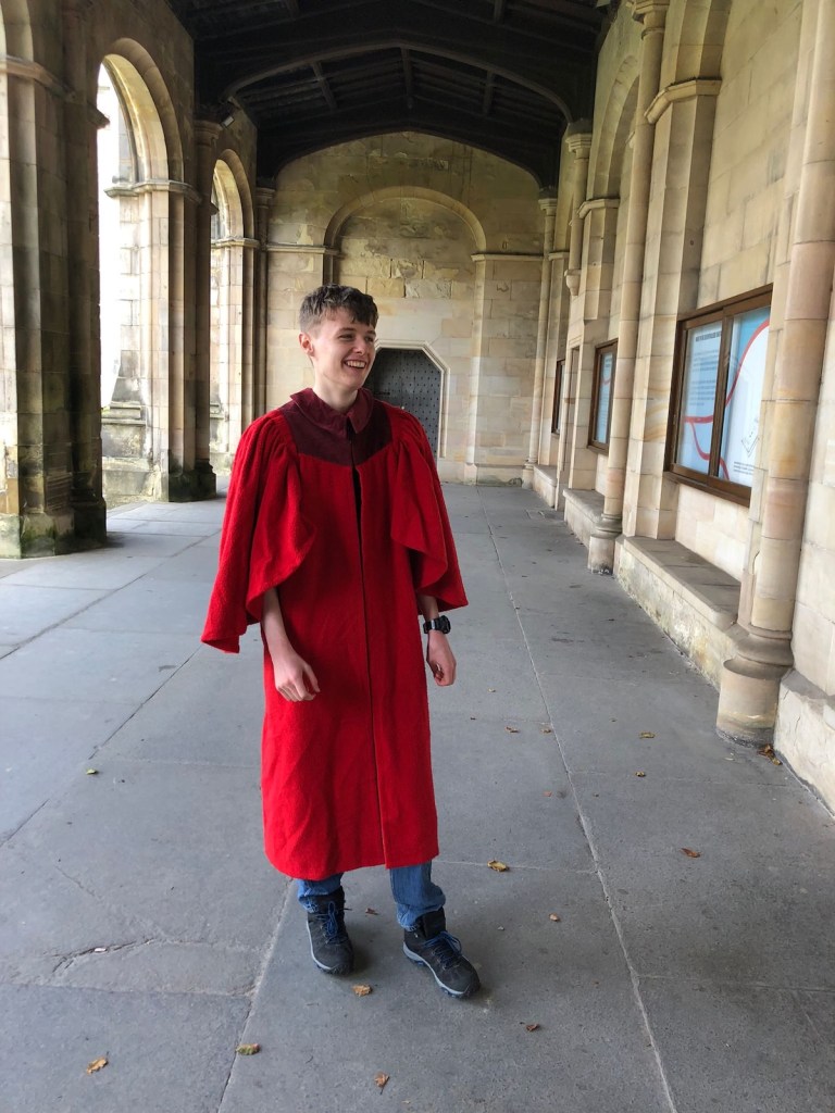 Daniel in his gown smiling at someone out of view.