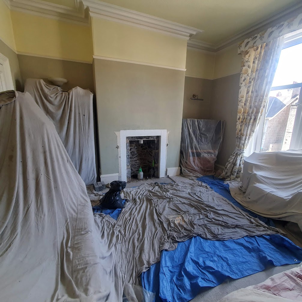 The room covered in dust sheets.