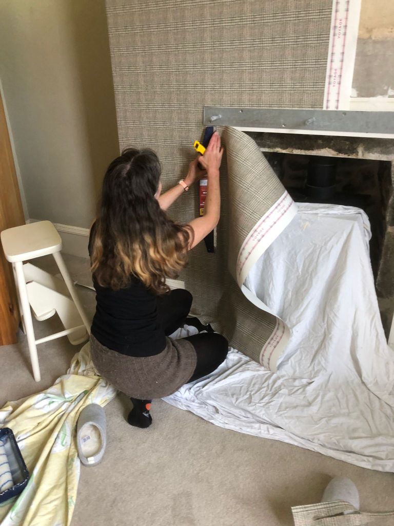 Me cutting the wallpaper on the side of the fire.