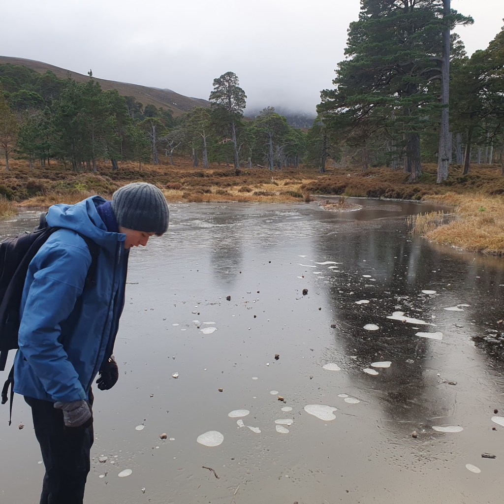 The lake frozen over with Daniel in the foreground.