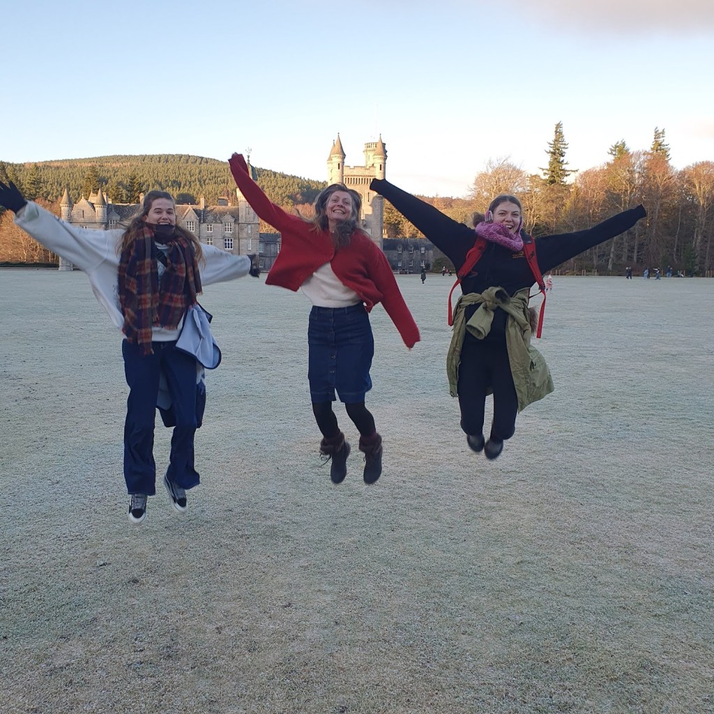Maddy, Rachel and Elizabeth jumping in front of Balmoral Castle