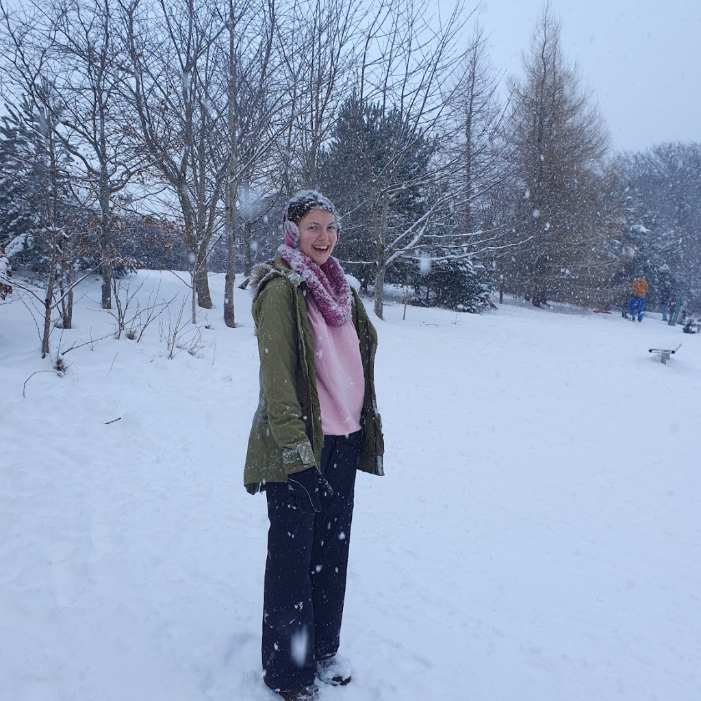 Elizabeth covered in snow and it's falling down