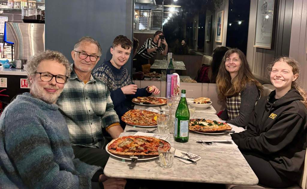 All of us at Pizza Express with lots of food on the table.