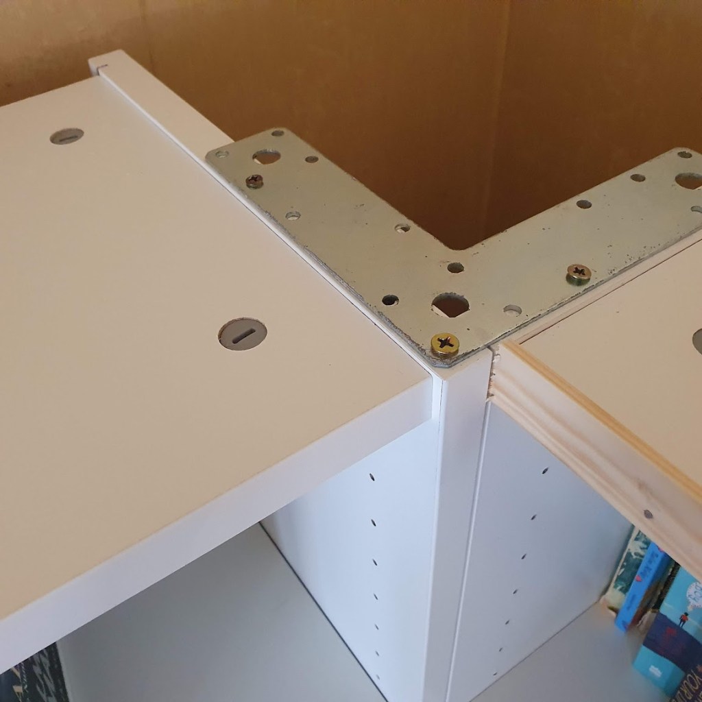 A metal bracket holding the two bookcases together