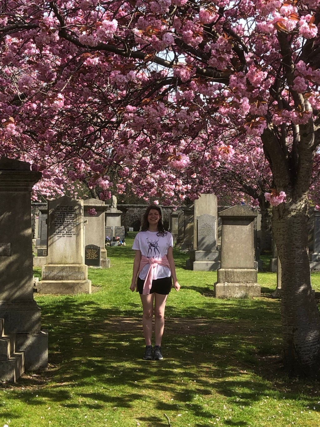 Elizabeth in the cemetery with lots of cherry blossoms